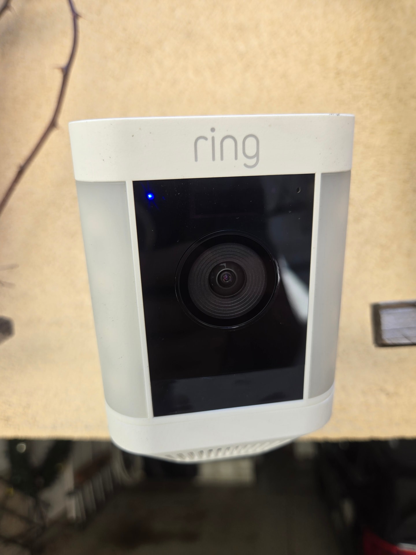 Installed Ring spotlight camera mounted under an eave and powered on
